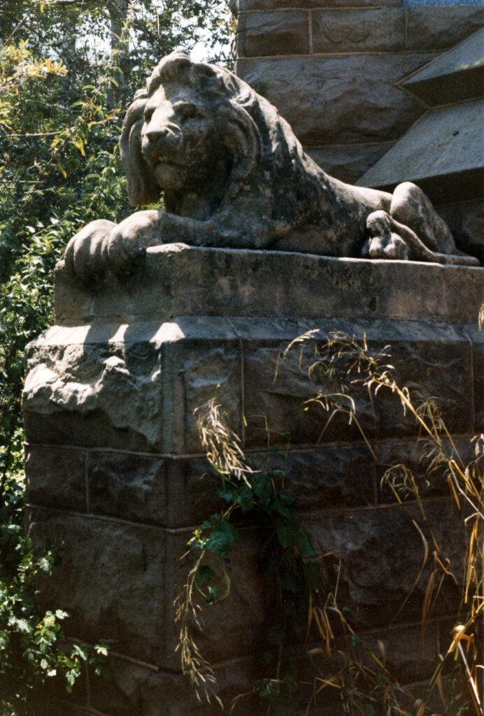 Close-up of stone lion statue at Foster Park entrance.
